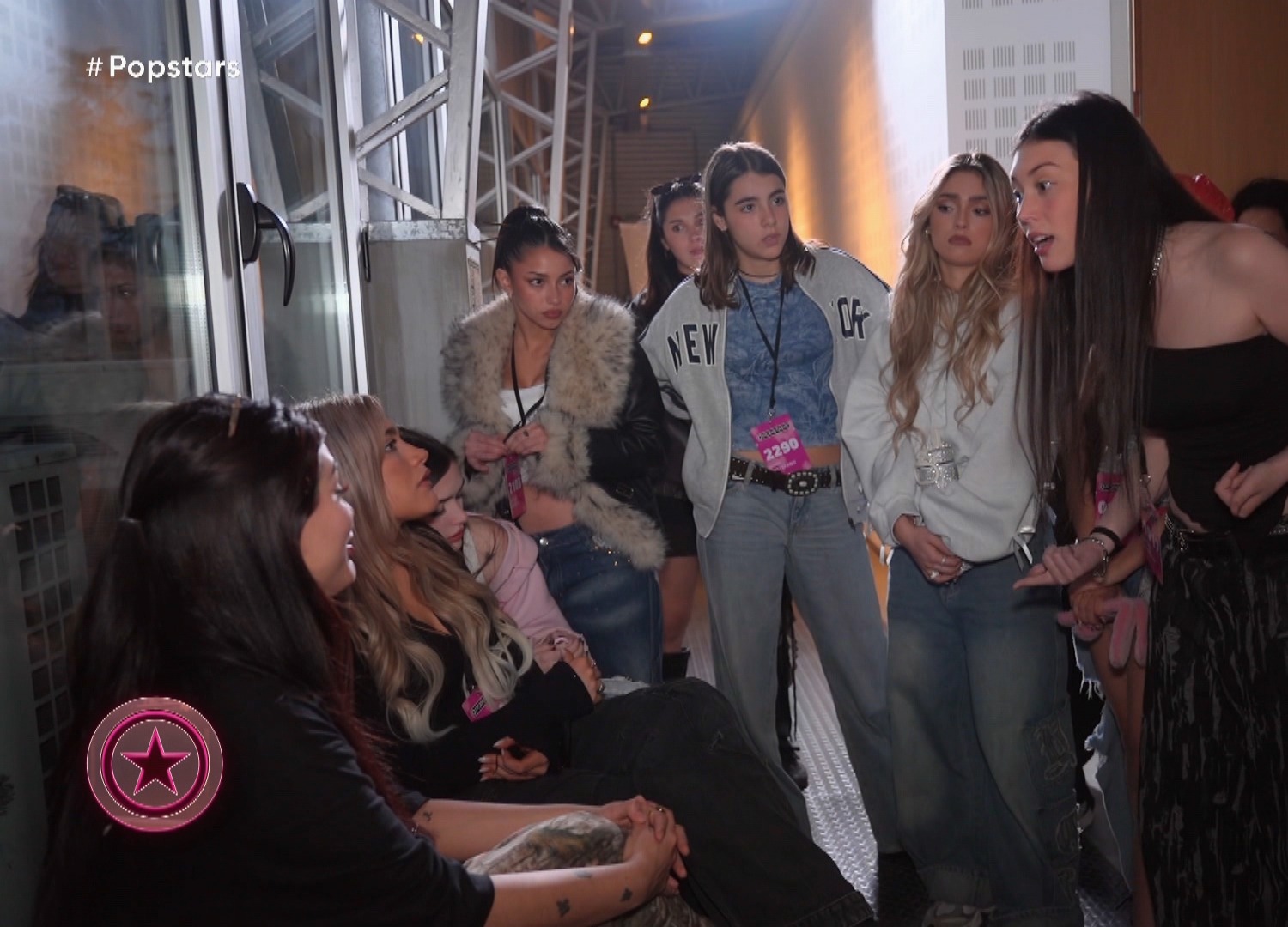 Compañeras de Popstars enfrentando a Bhae en un pasillo