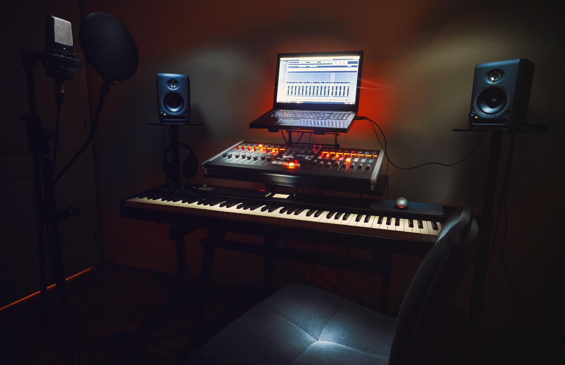 Home studio con notebook, consola MIDI y teclado