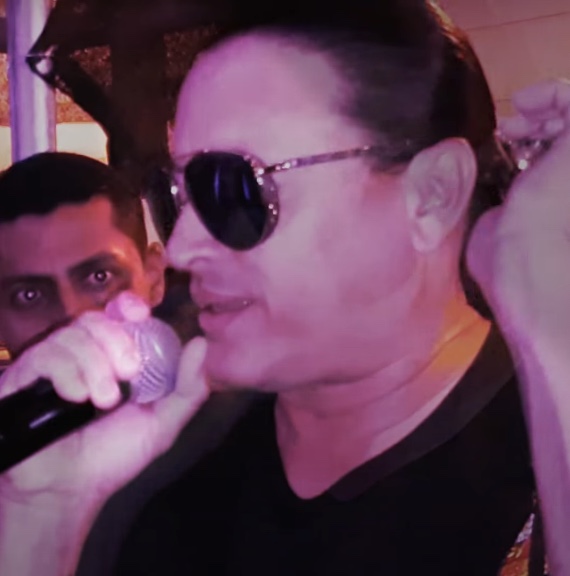 Elvis Crespo cantando, con micrófono