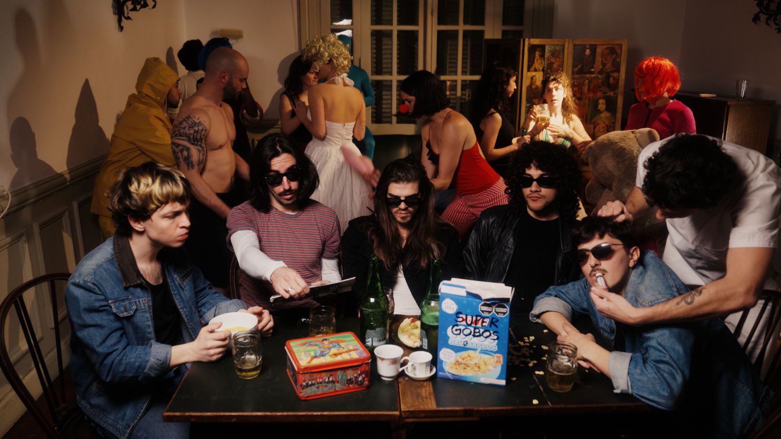 Still del videoclip de Superbicho: la banda en una mesa, desayunando